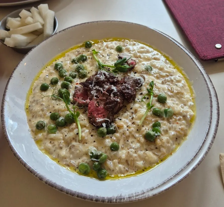 Truffle pea risotto topped with a generous piece of meat