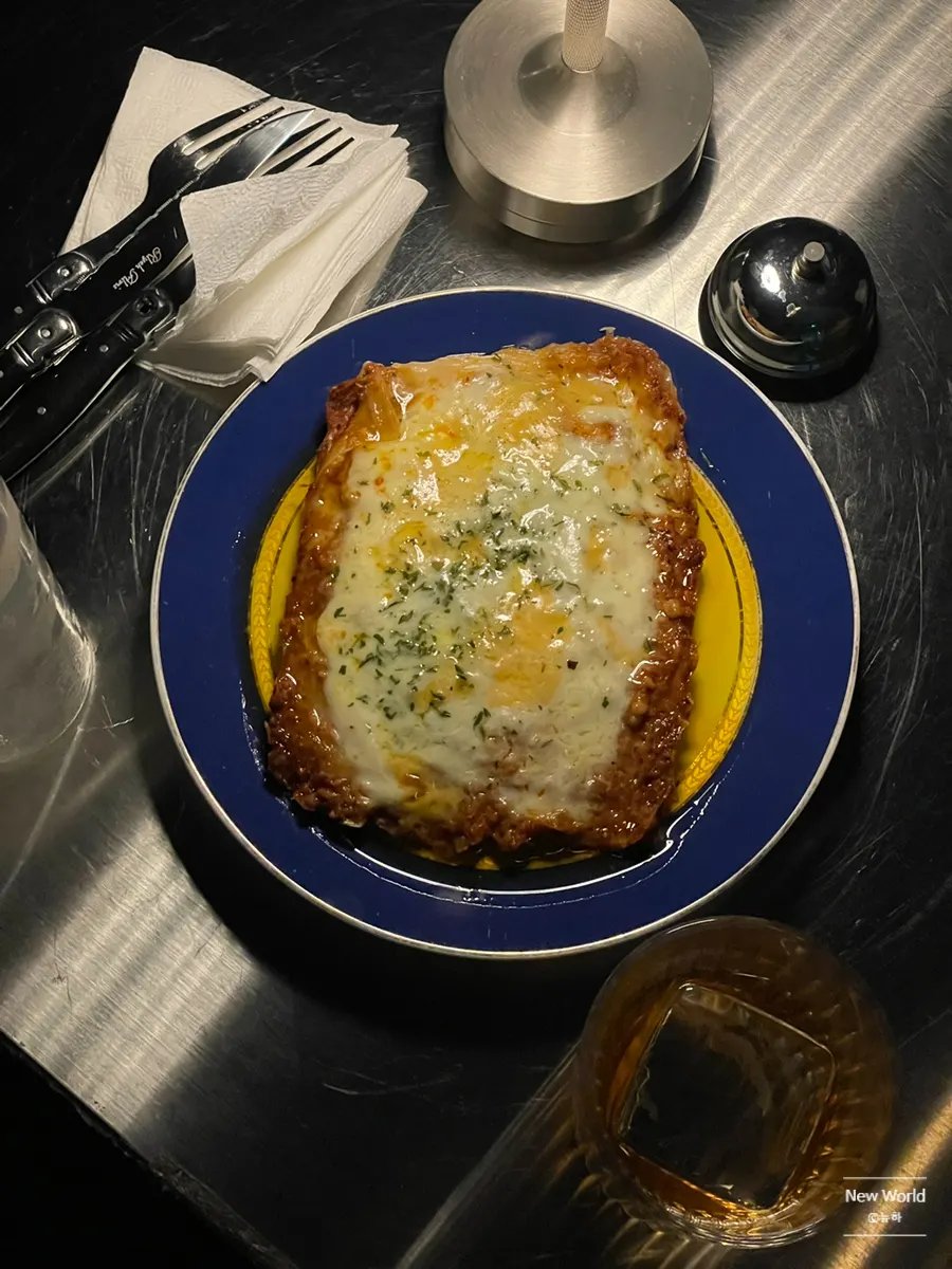 A bite of lasagna dipped in truffle oil