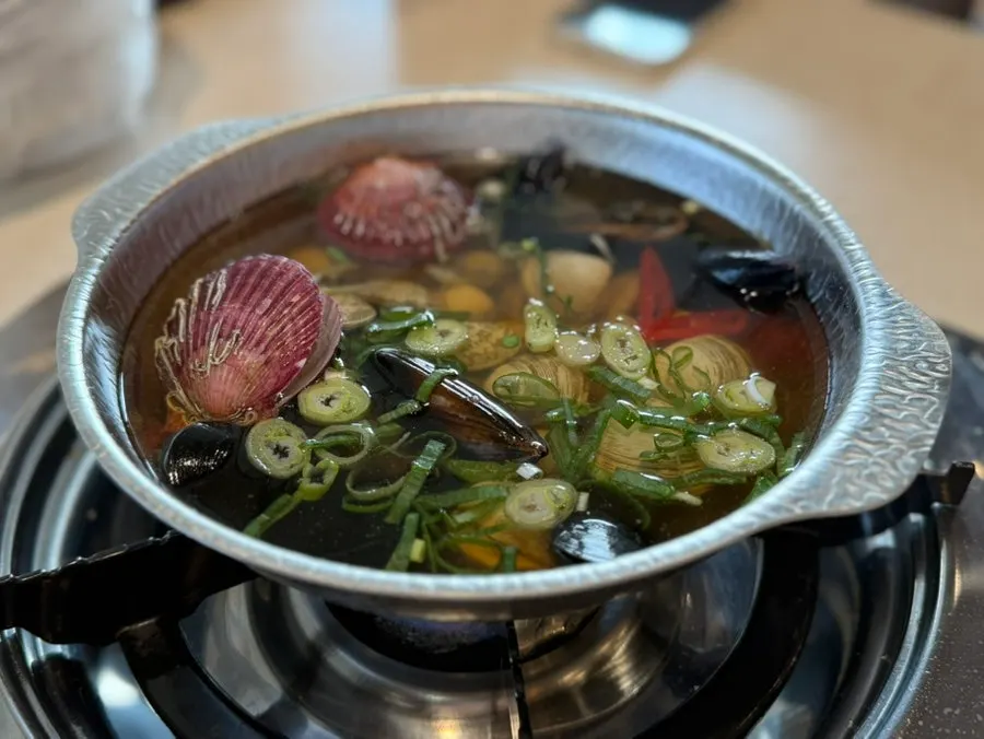 A bowl of clear-broth clam soup
