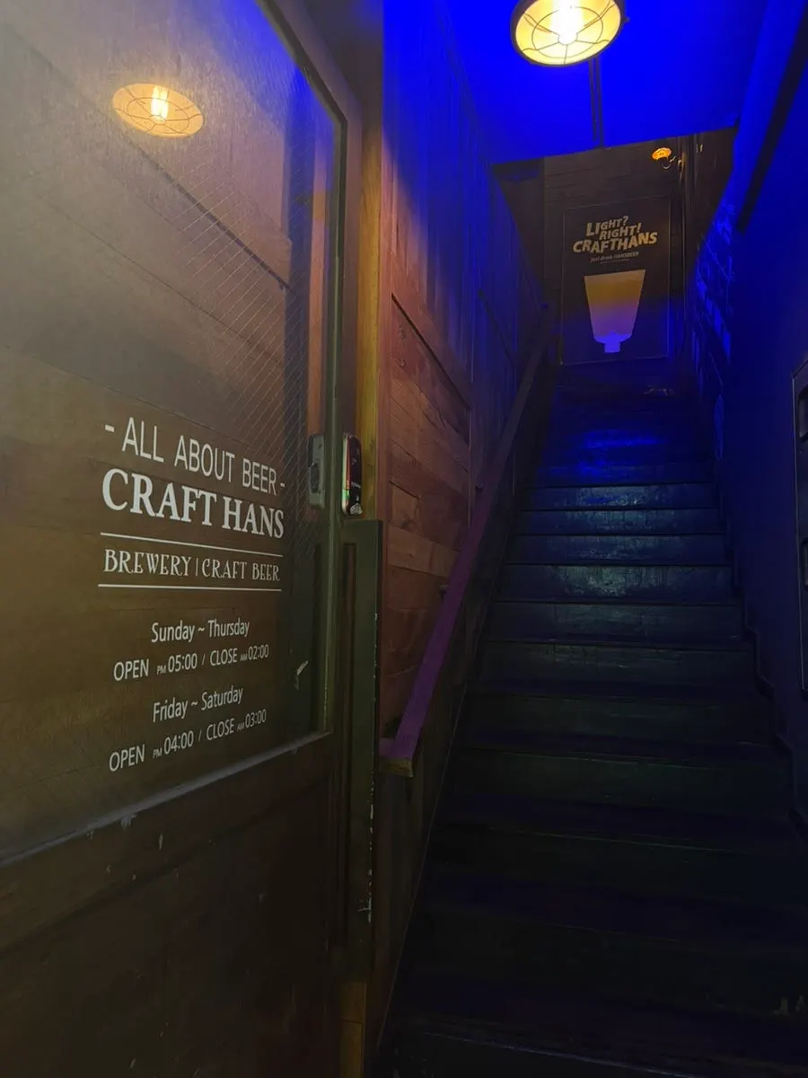 Staircase with wood-tone brick walls and blue lighting