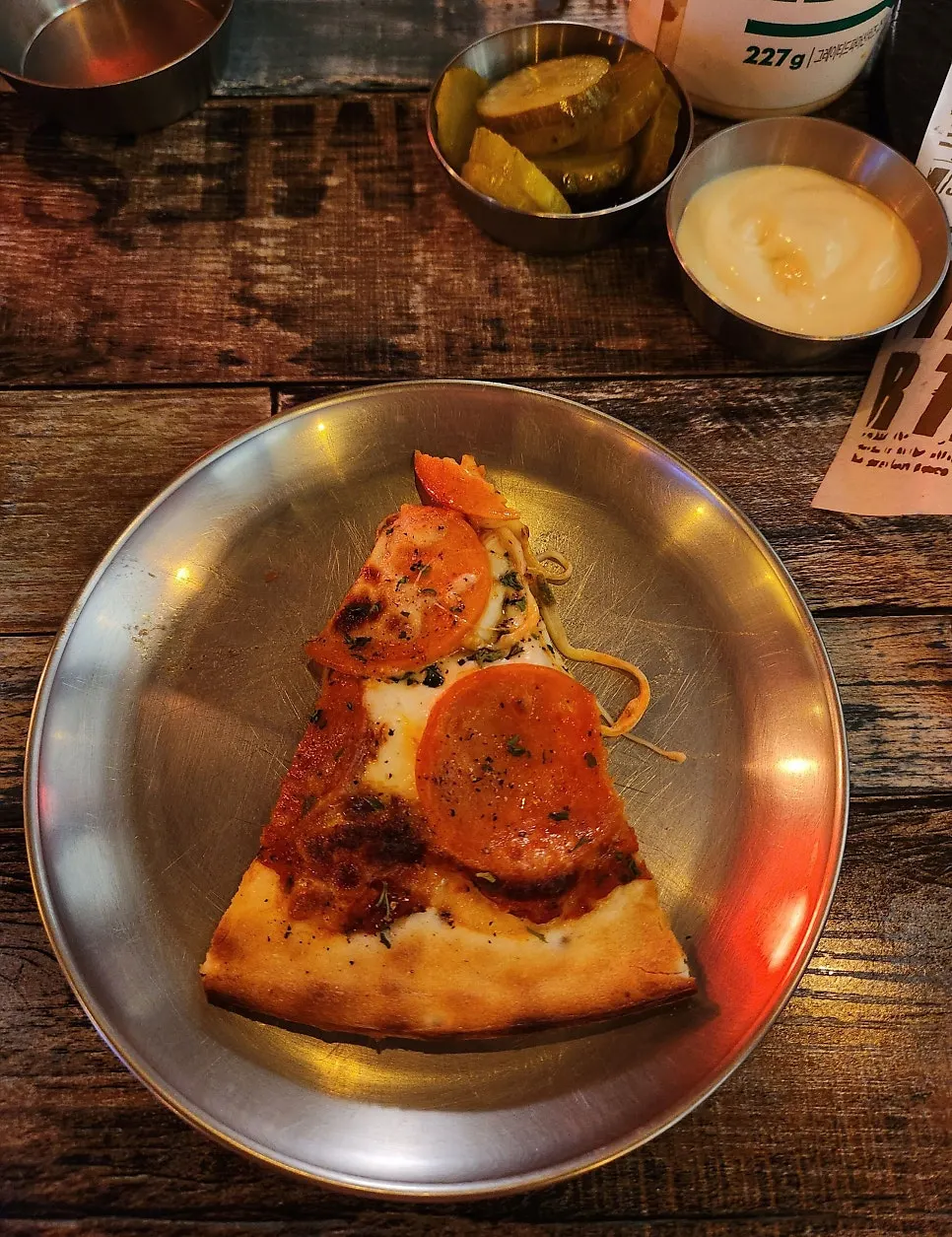 A pizza slice dipped in garlic sauce