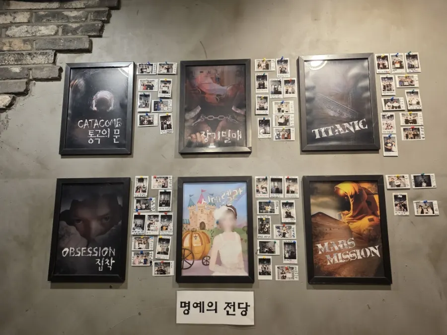테마 포스터와 방문객 폴라로이드가 걸린 벽면