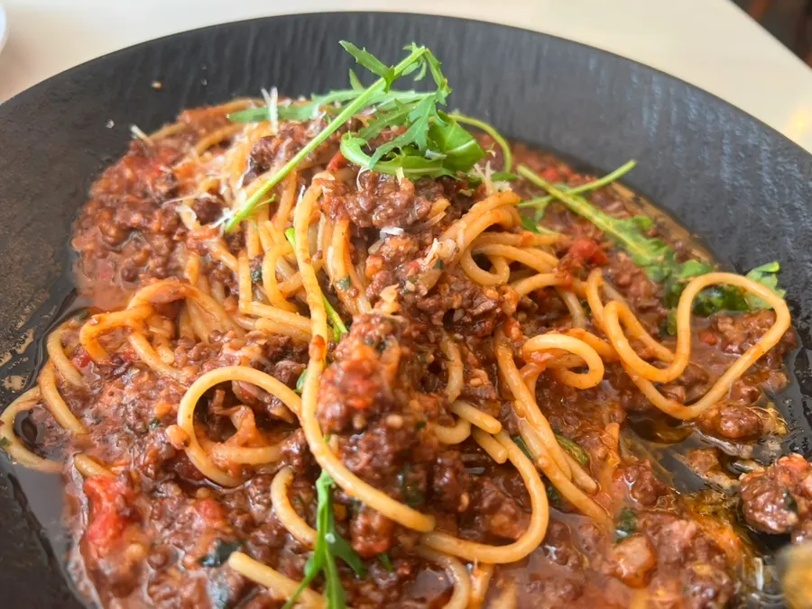 Pasta noodles coated in rich bolognese sauce