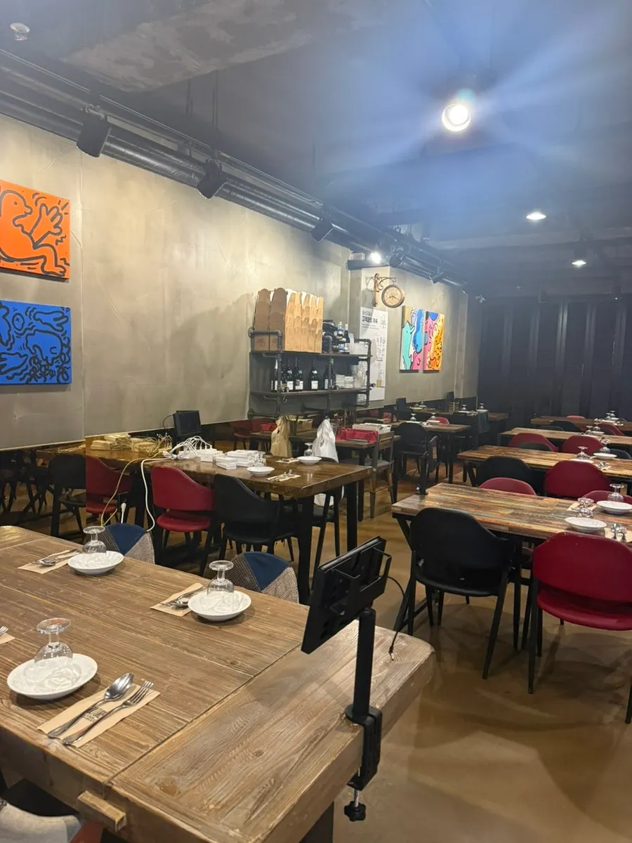 그레이 톤 벽면에 팝아트 액자가 걸린 컬쳐드 매장 내부