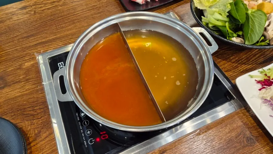Split pot holding two different broths
