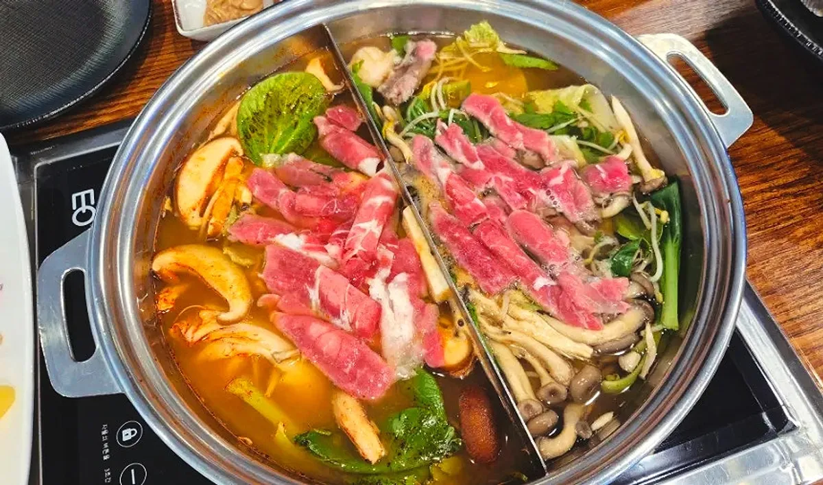 Shabu-shabu cooking with vegetables and meat in the split pot