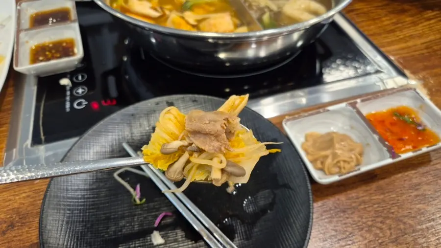 Dipping a wolnamssam wrap into sauce