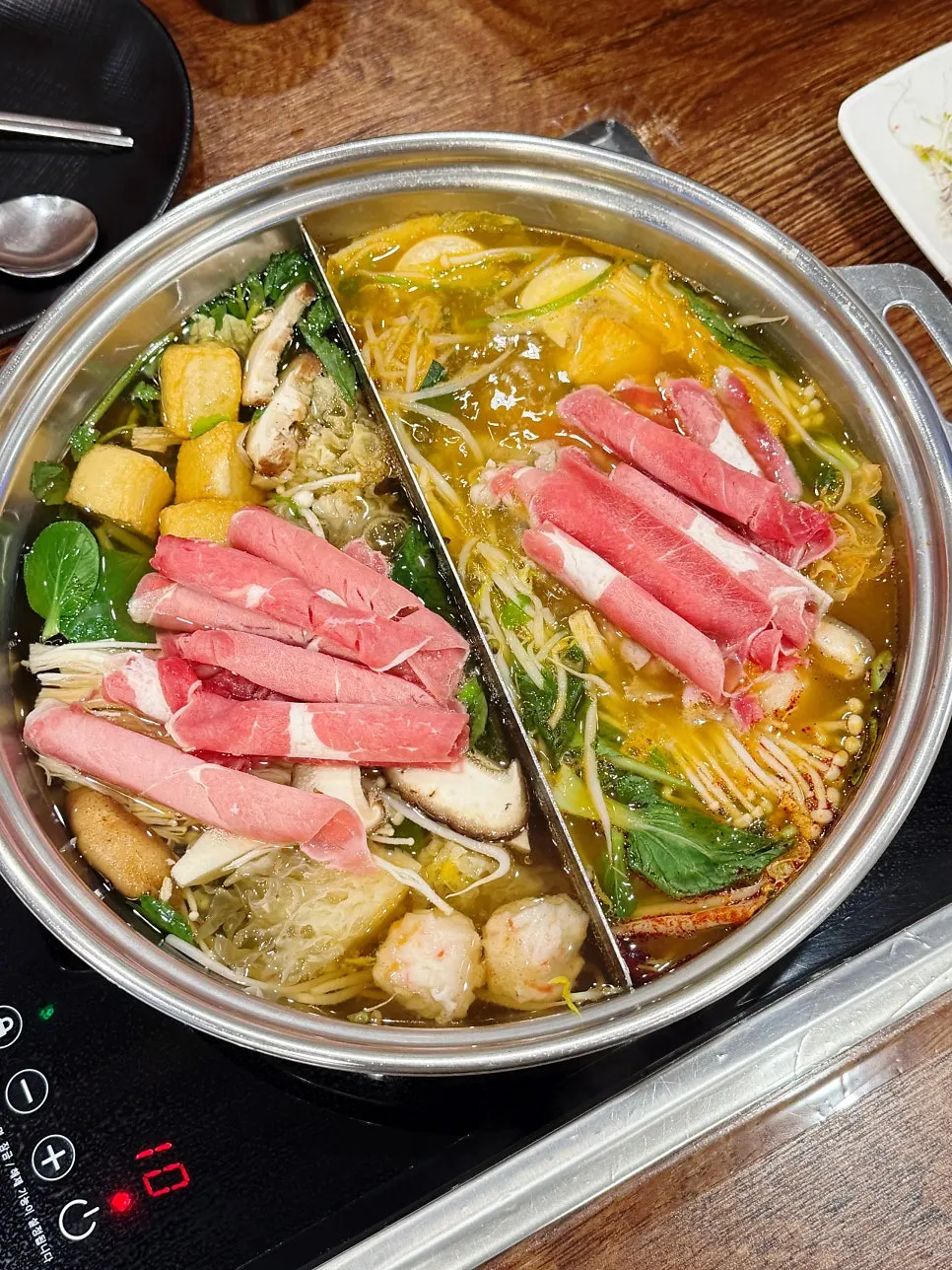 A pot split between clear and spicy broth