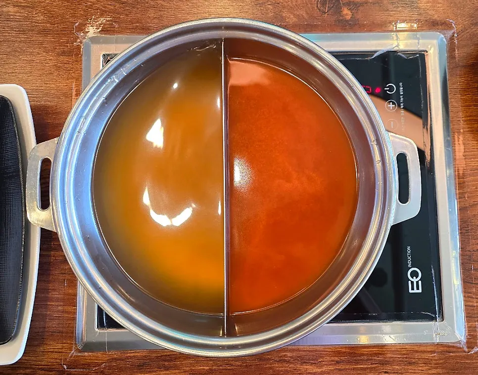 Shabu-shabu cooking in the split seafood and spicy broth pot