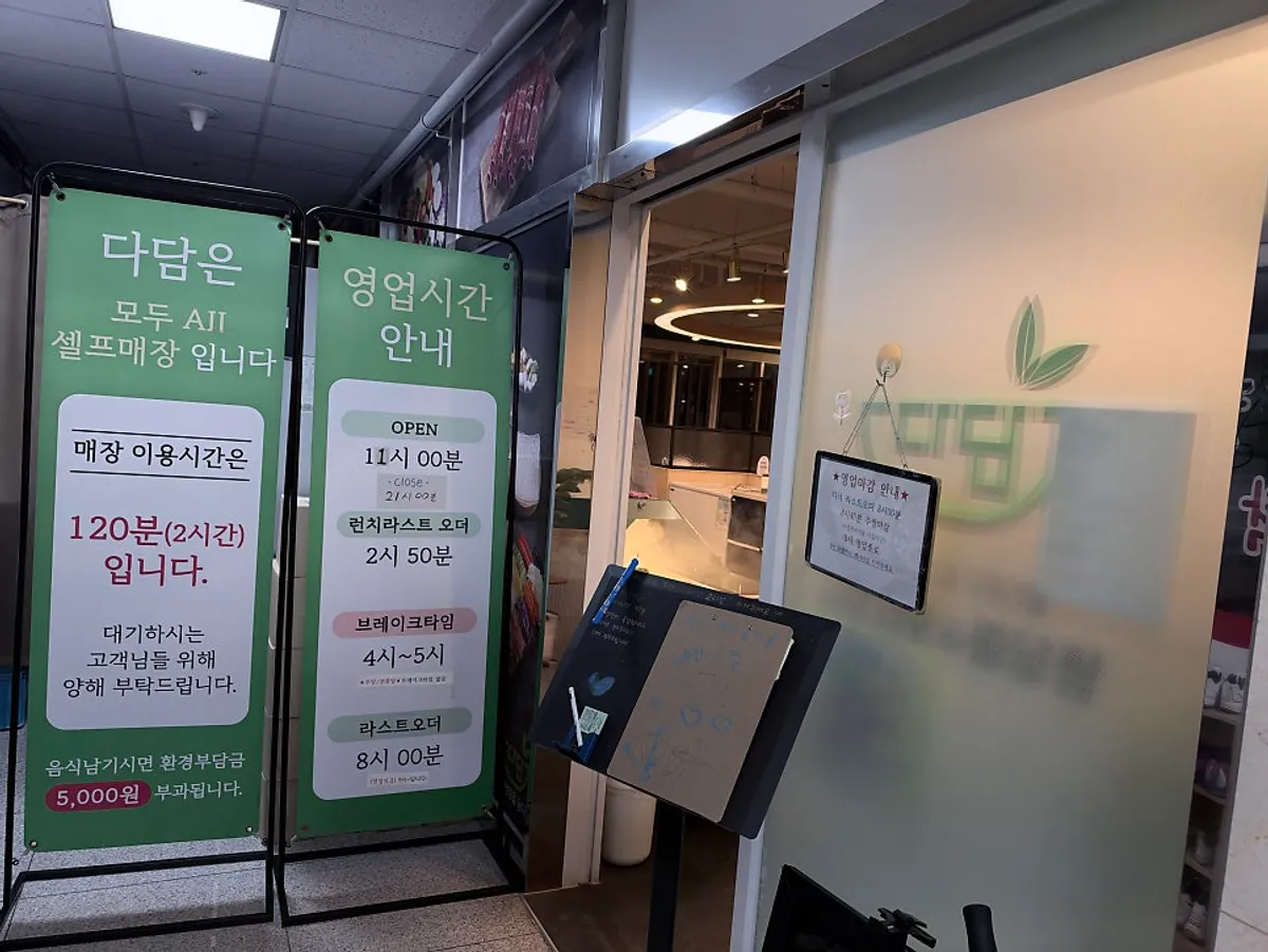 다담샤브샤브 위례점 입구의 영업시간·이용 규칙 입간판