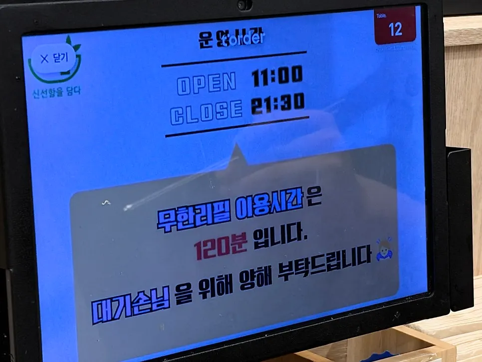 테이블에 설치된 티오더 화면의 셀프바 이용 안내