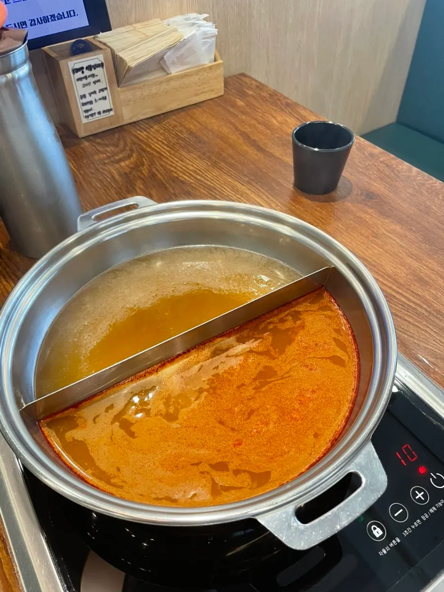 Pot with seafood broth and spicy broth split half-and-half
