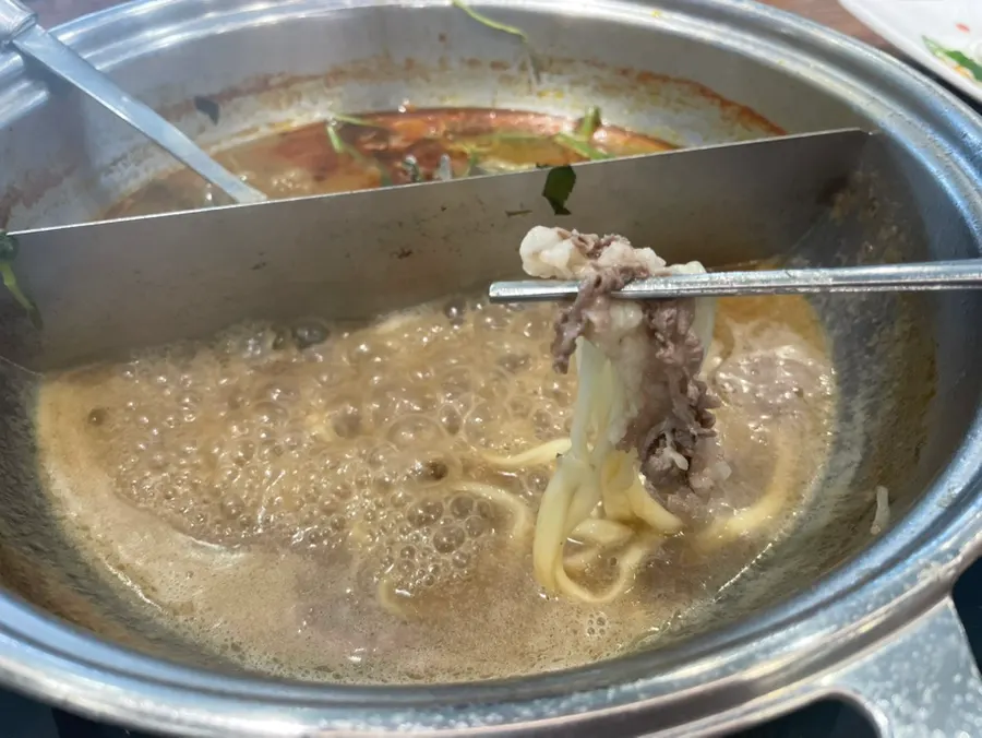 Kalguksu noodles cooked in both seafood and spicy broths