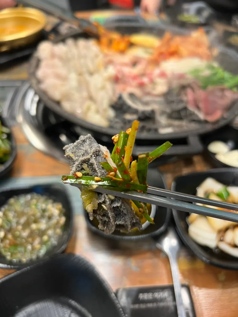 Gopchang and vegetables browning golden on the grill