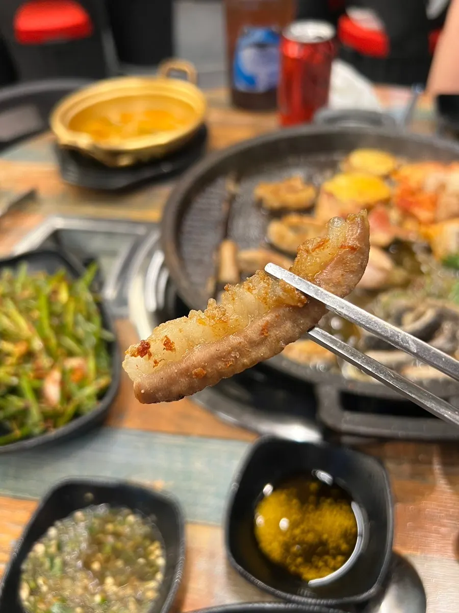 A piece of grilled beef intestine dipped in sauce