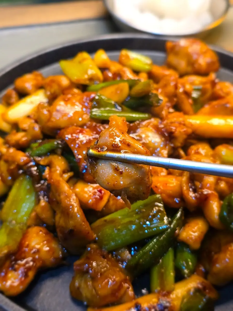 Grilled chicken cooking with green onion and whole garlic