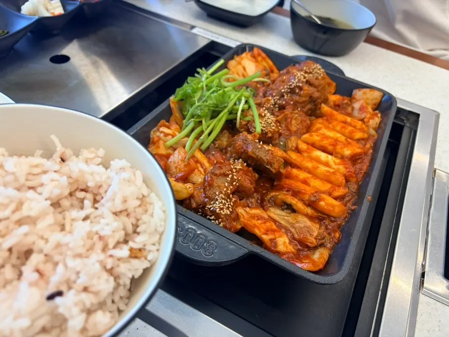 Spicy braised pork ribs topped with minari