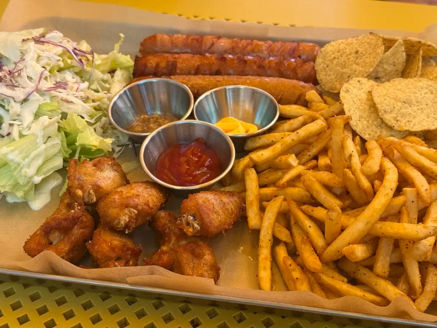 Close-up of the platter with fries, sausage, and chicken drumettes