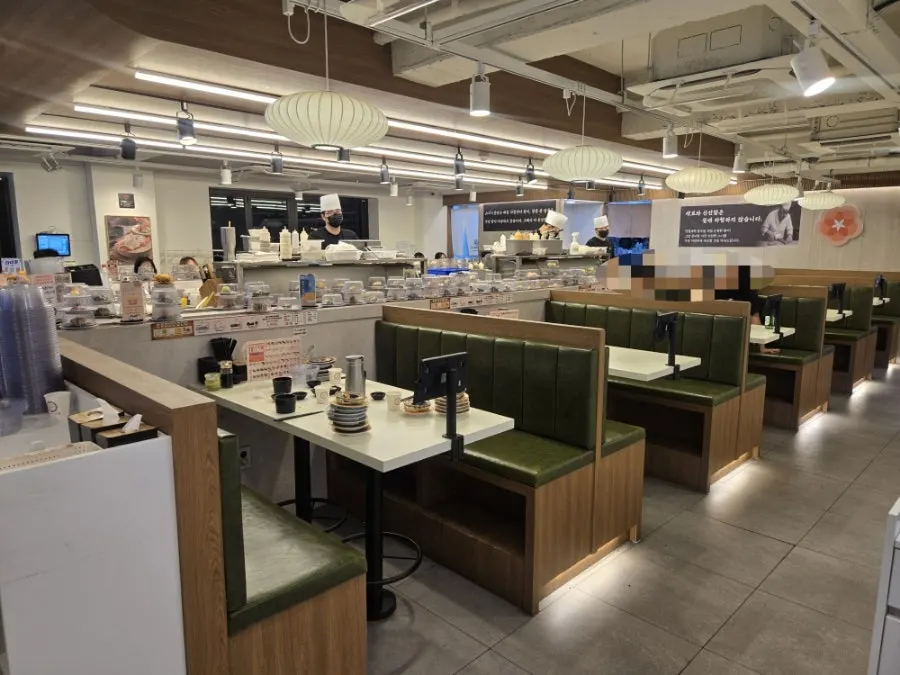 Table seats and counter seats on either side of the sushi rail