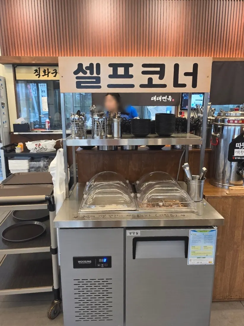 Self-serve side dish corner at Daedae Myeonok
