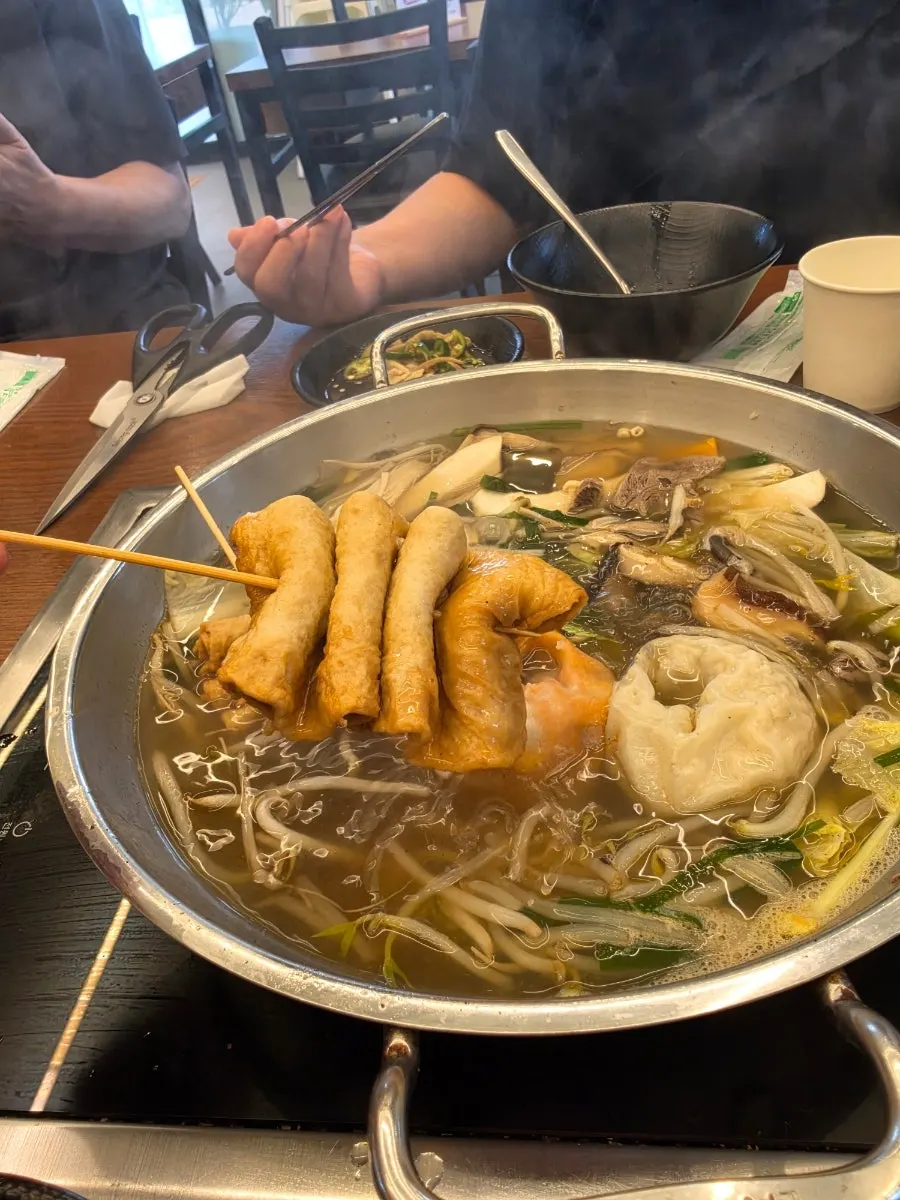Meat and kimchi dumplings fished out of the hot pot
