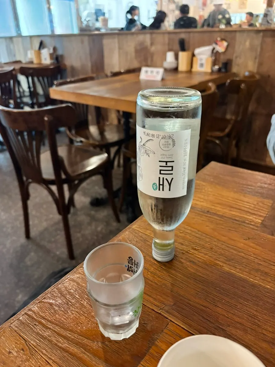 A shot of soju placed alongside aged sashimi