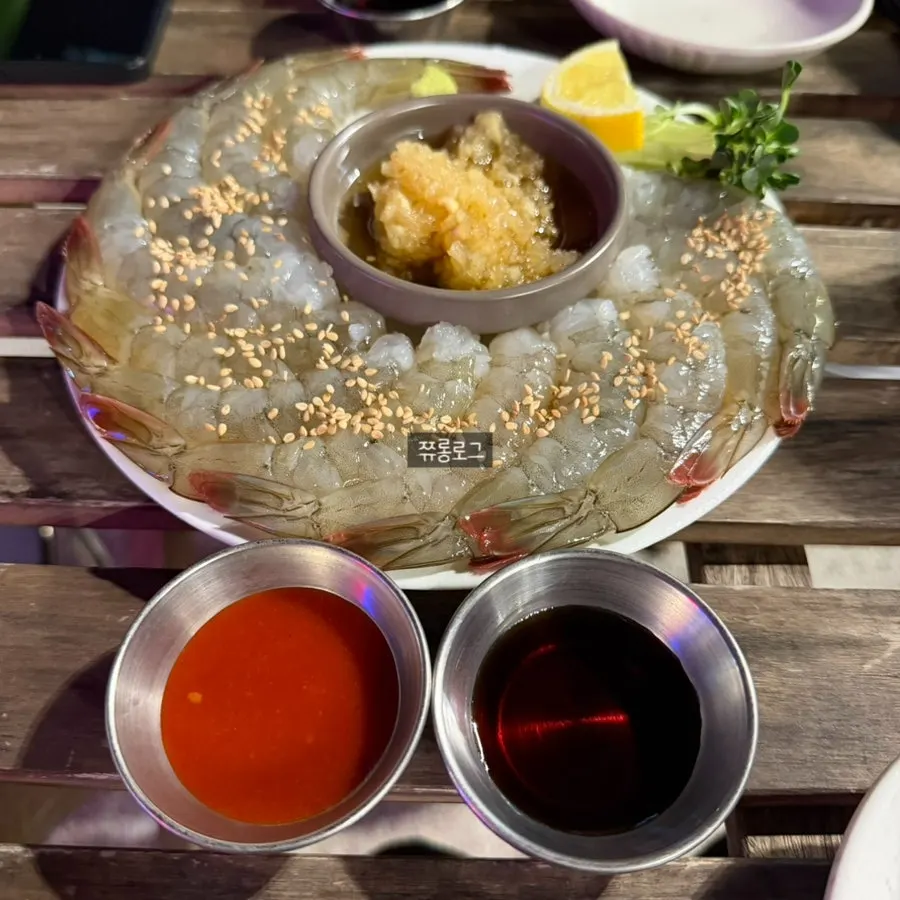 Raw shrimp sashimi plated with dipping sauces