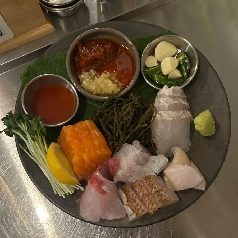 A full spread of sashimi and side dishes ordered at Daegang