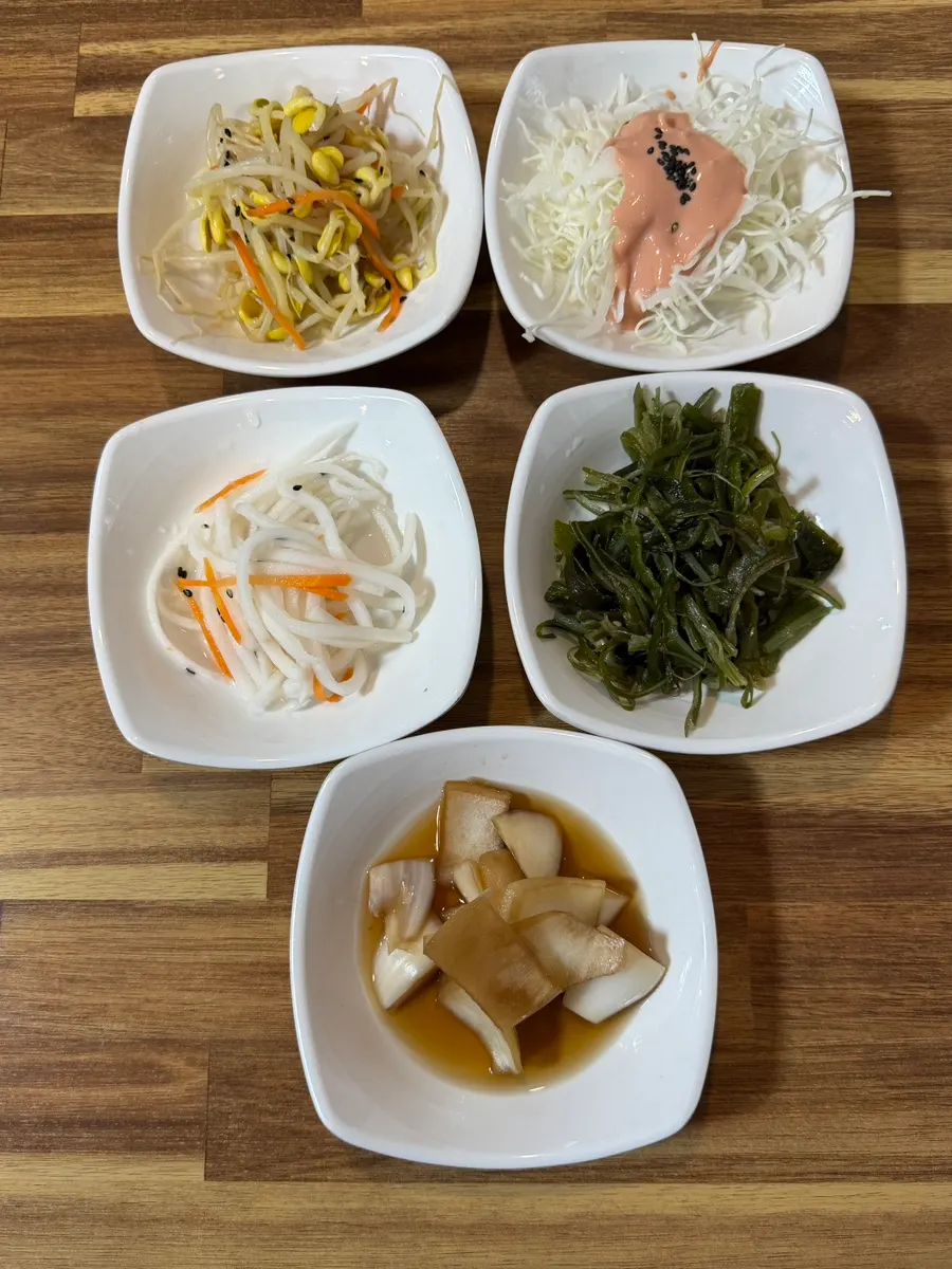 Seasoned bean sprouts and cabbage salad among basic side dishes