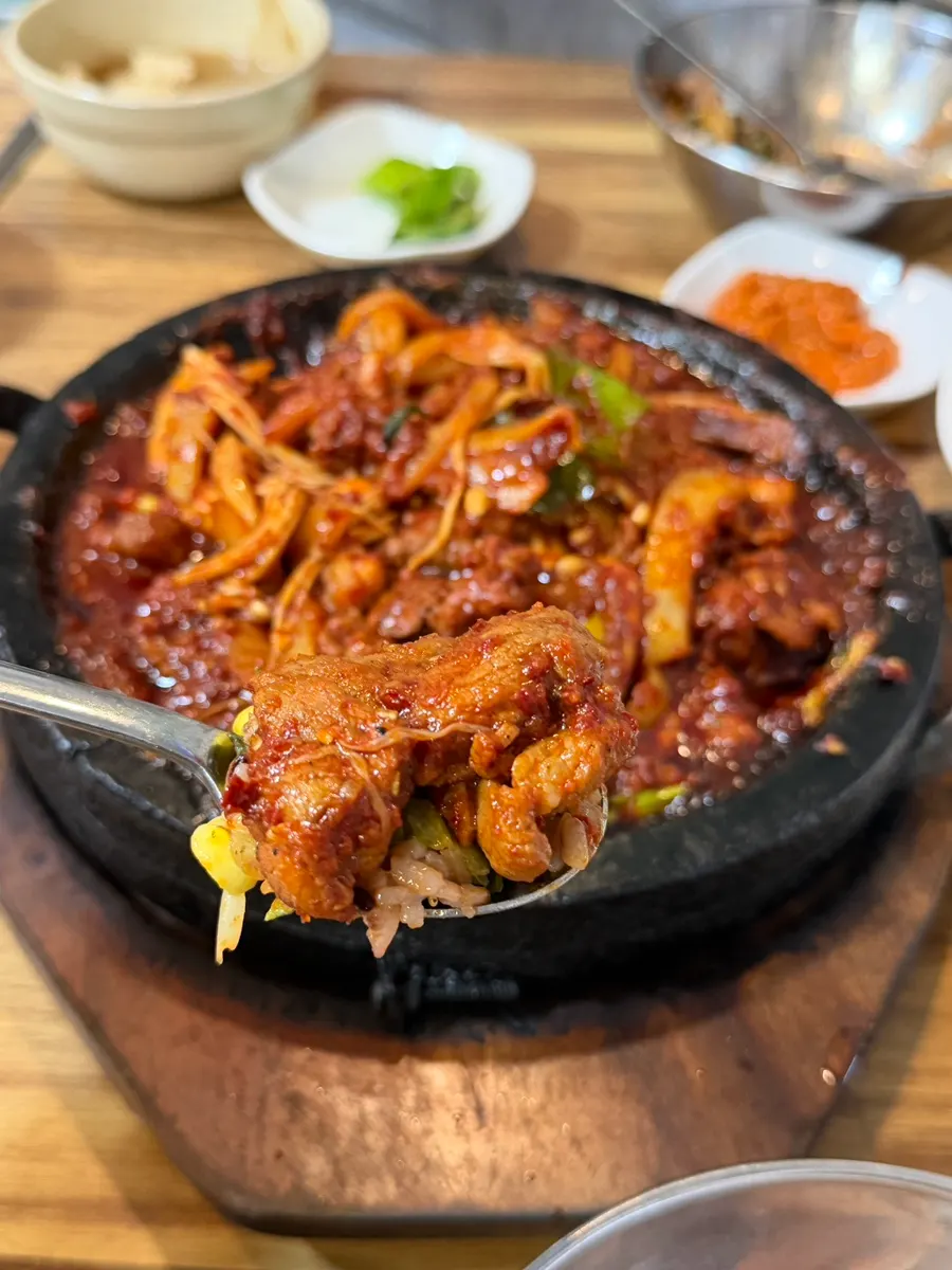 A bite of ssam piled with side dishes