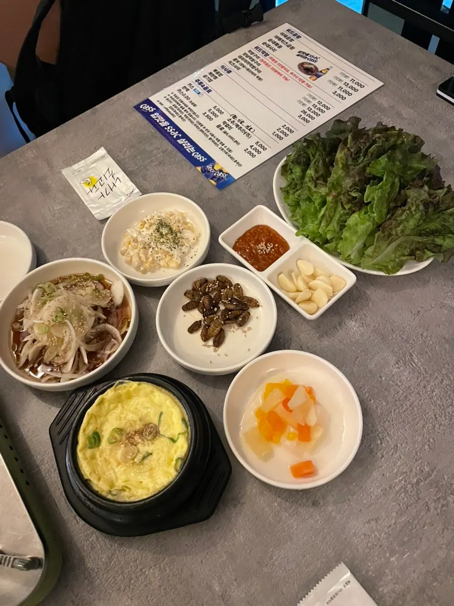 Side dishes at With Gopchang with corn salad, beondegi, and wrap vegetables