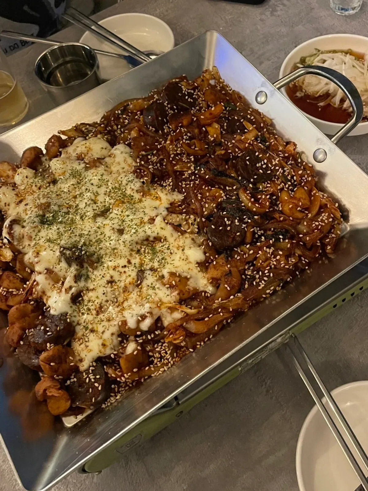 Cooked vegetable gopchang served on a hot plate at With Gopchang