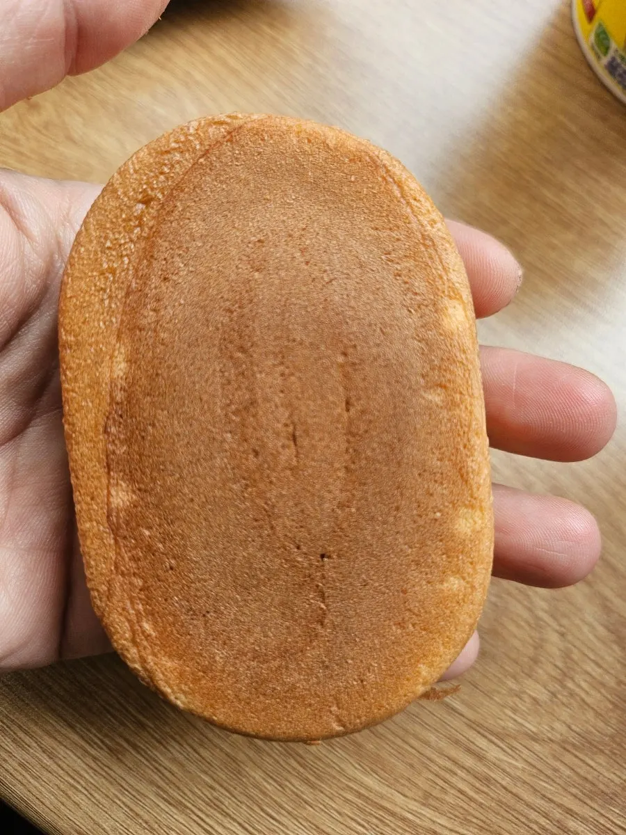 Daesin peanut bread held in the palm of a hand