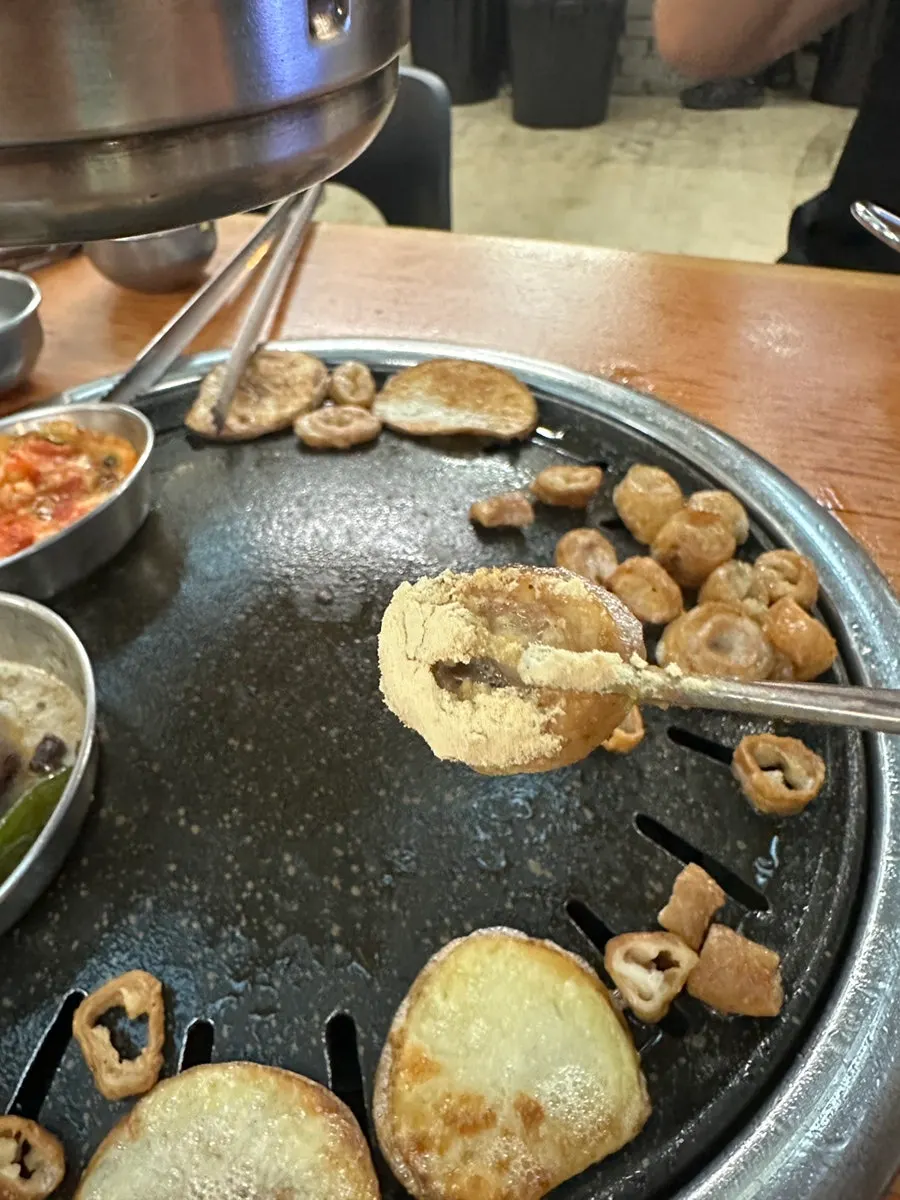 A piece of makchang dipped in red sauce