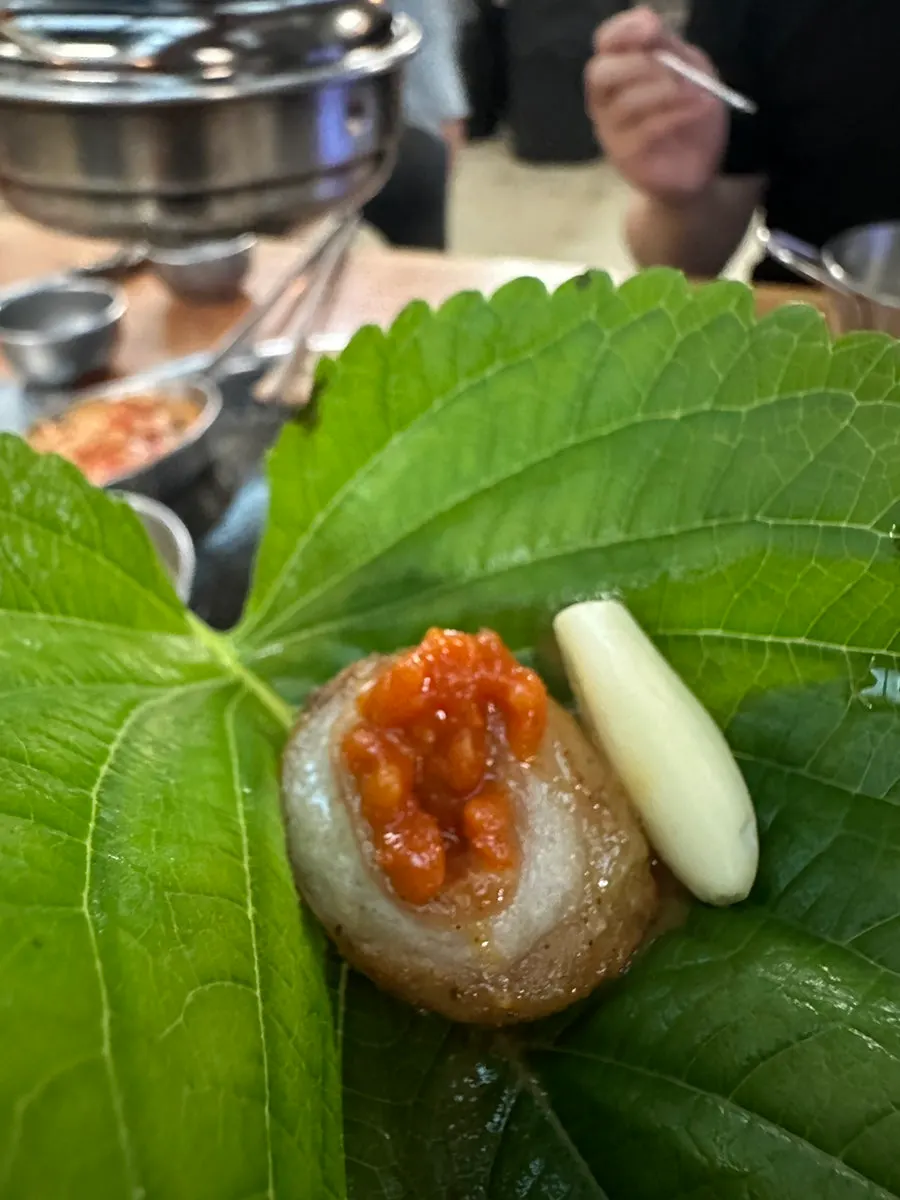 Perilla leaf wrap topped with makchang and garlic