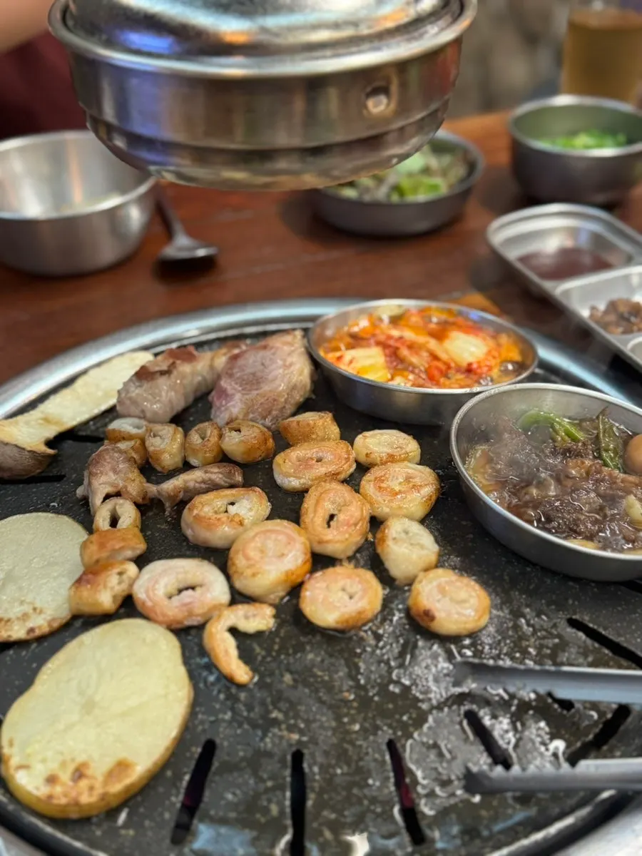 Charcoal grill topped with makchang and accompaniments