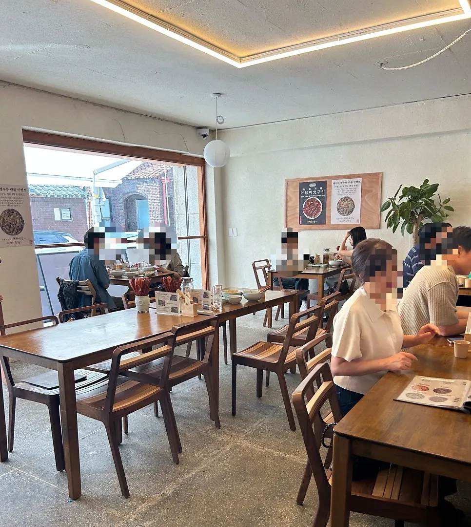 Korean restaurant interior lit by full-height window sunlight