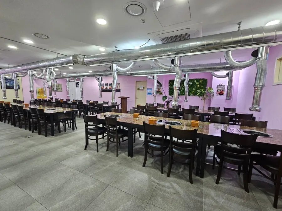 Seating area with floor-to-ceiling windows and wood-toned lighting