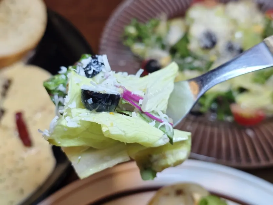 Salad topped with cheese, black olives, and cherry tomatoes