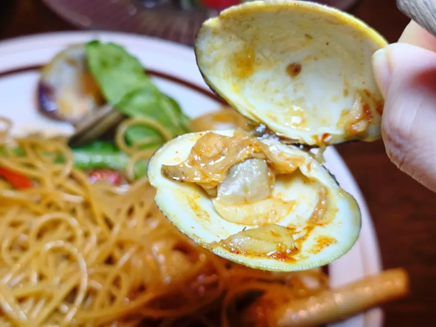 A bite of pasta with a large shrimp lifted up