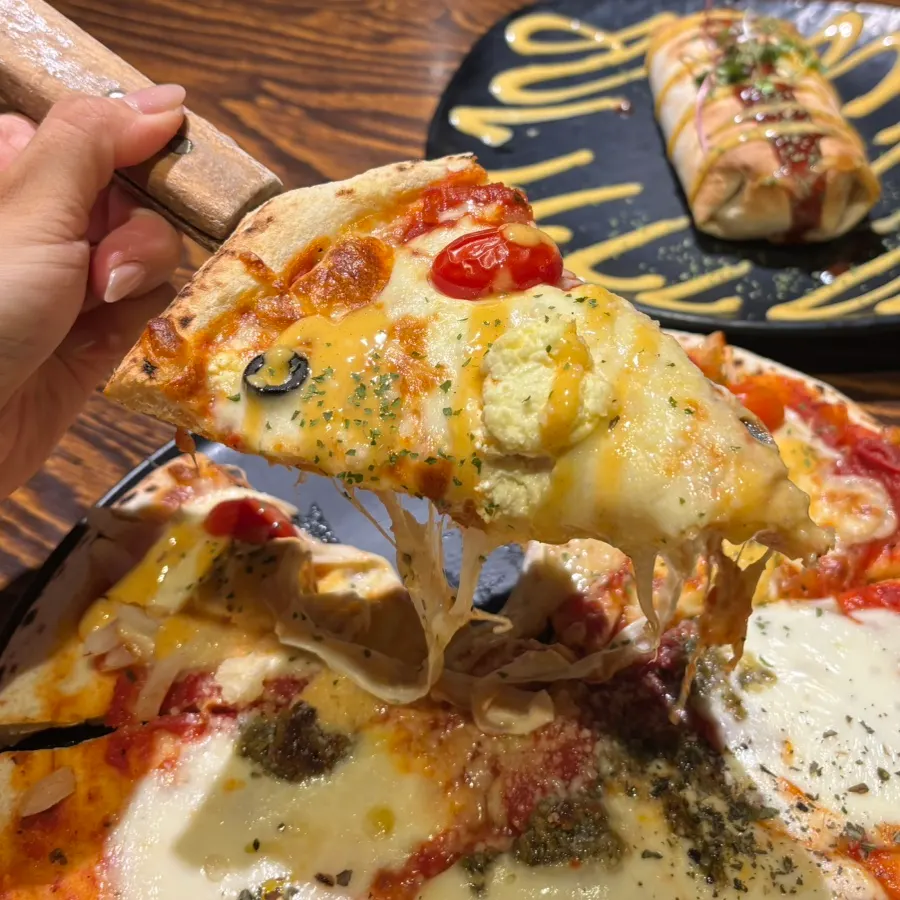 A slice of cream cheese tomato pizza