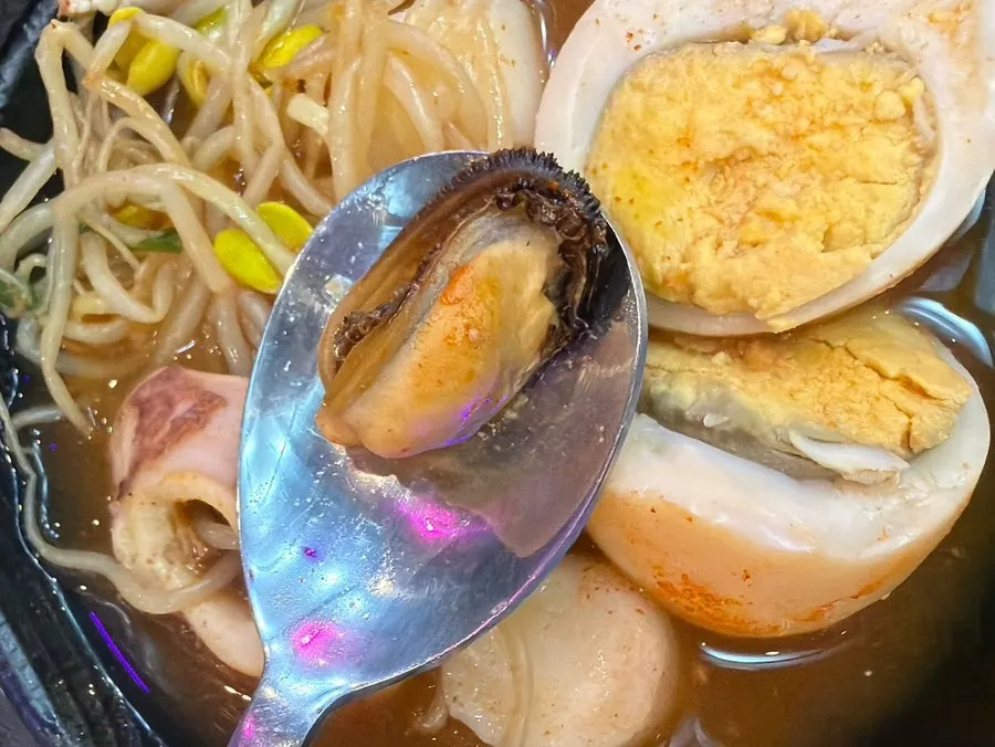 Small plate of bean sprouts, egg, rice cake, and radish