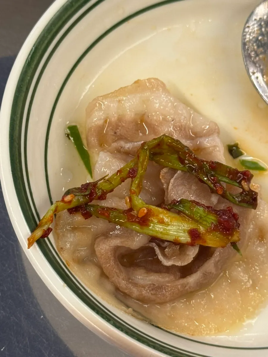 A piece of naengsam dipped in salt