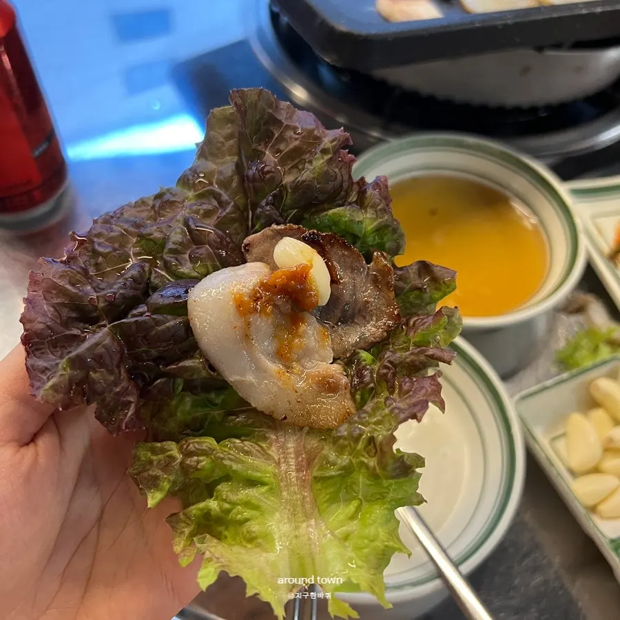 A wrap of naengsam topped with green onion kimchi