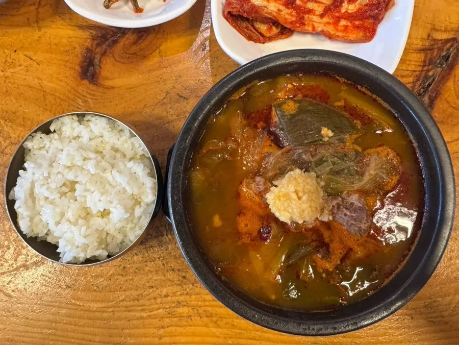 A table with oxtail gomtang, ttaro-gukbap, and basic side dishes