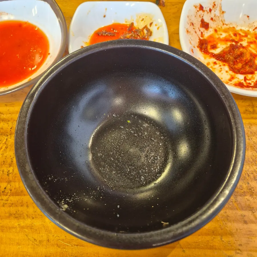 Self-serve banchan corner with onions, peppers, and anchovies at Hanwoojang