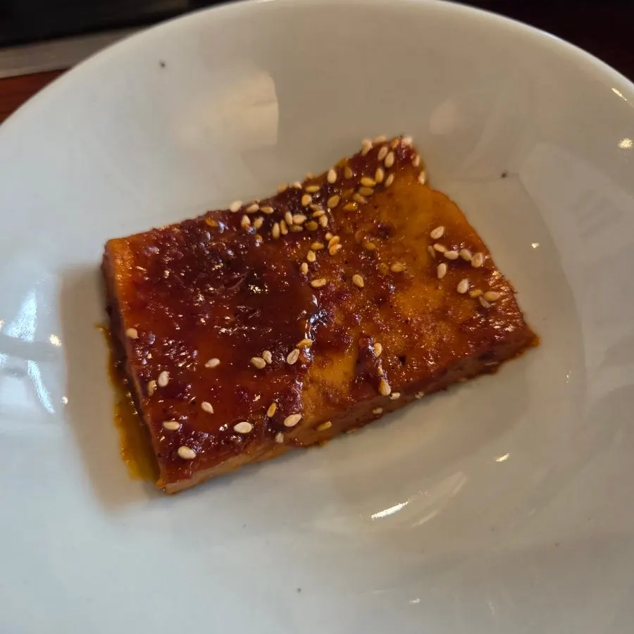 A large piece of tofu scooped out of the pot