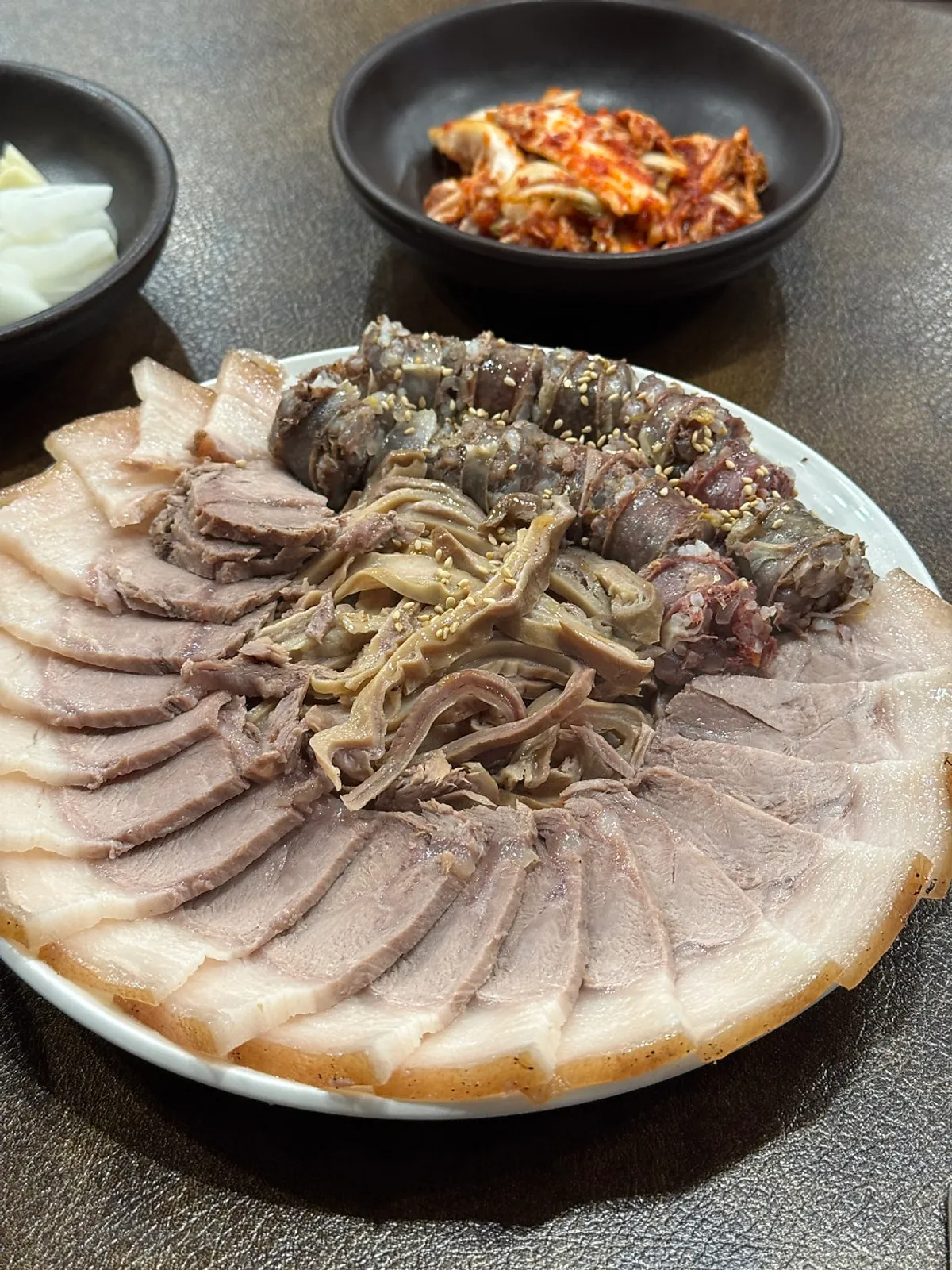 Assorted suyuk and soju spread at Ungjin Dalseo Dwaeji Gukbap