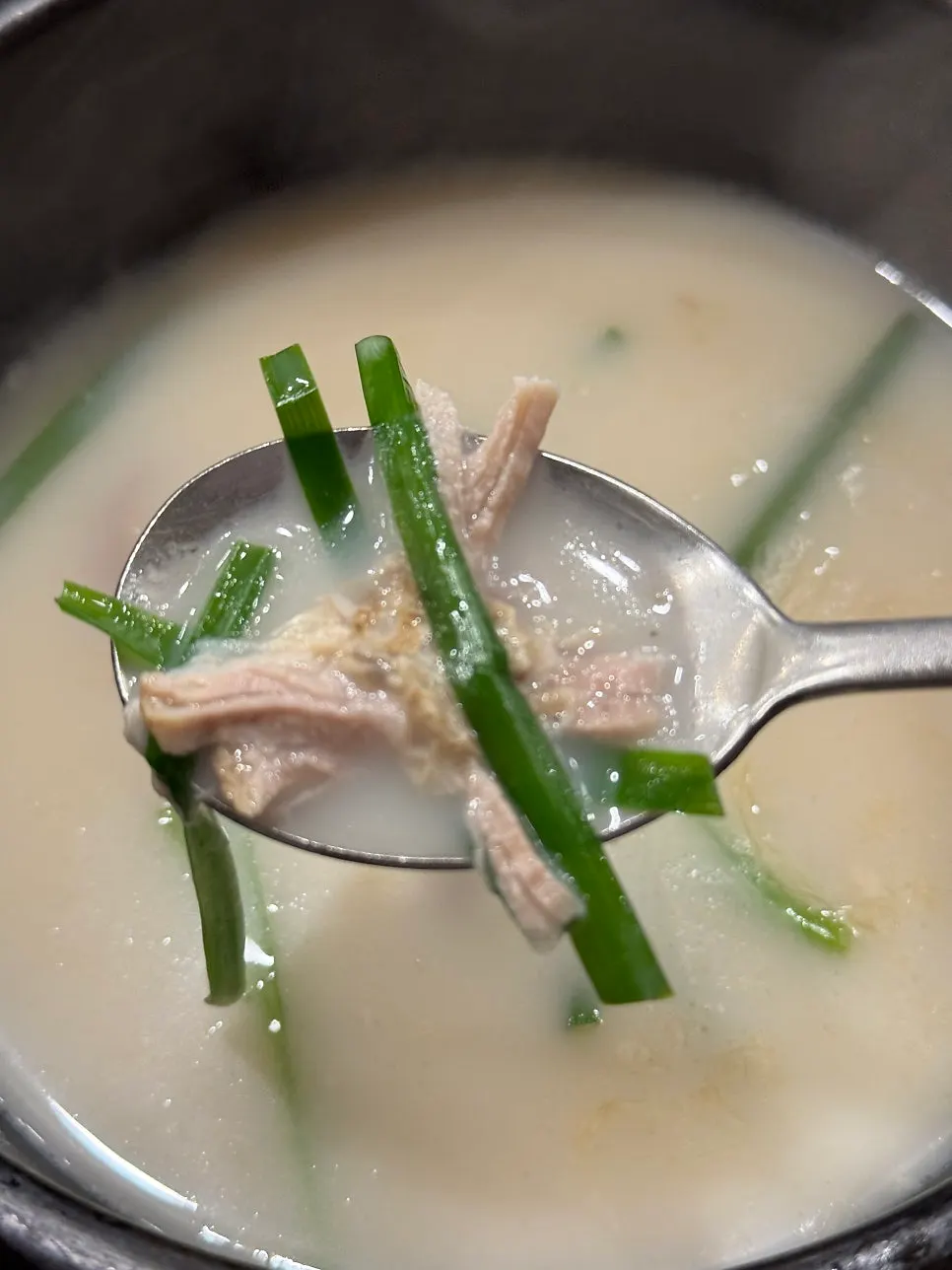 Milky broth in an earthenware pot loaded with meat