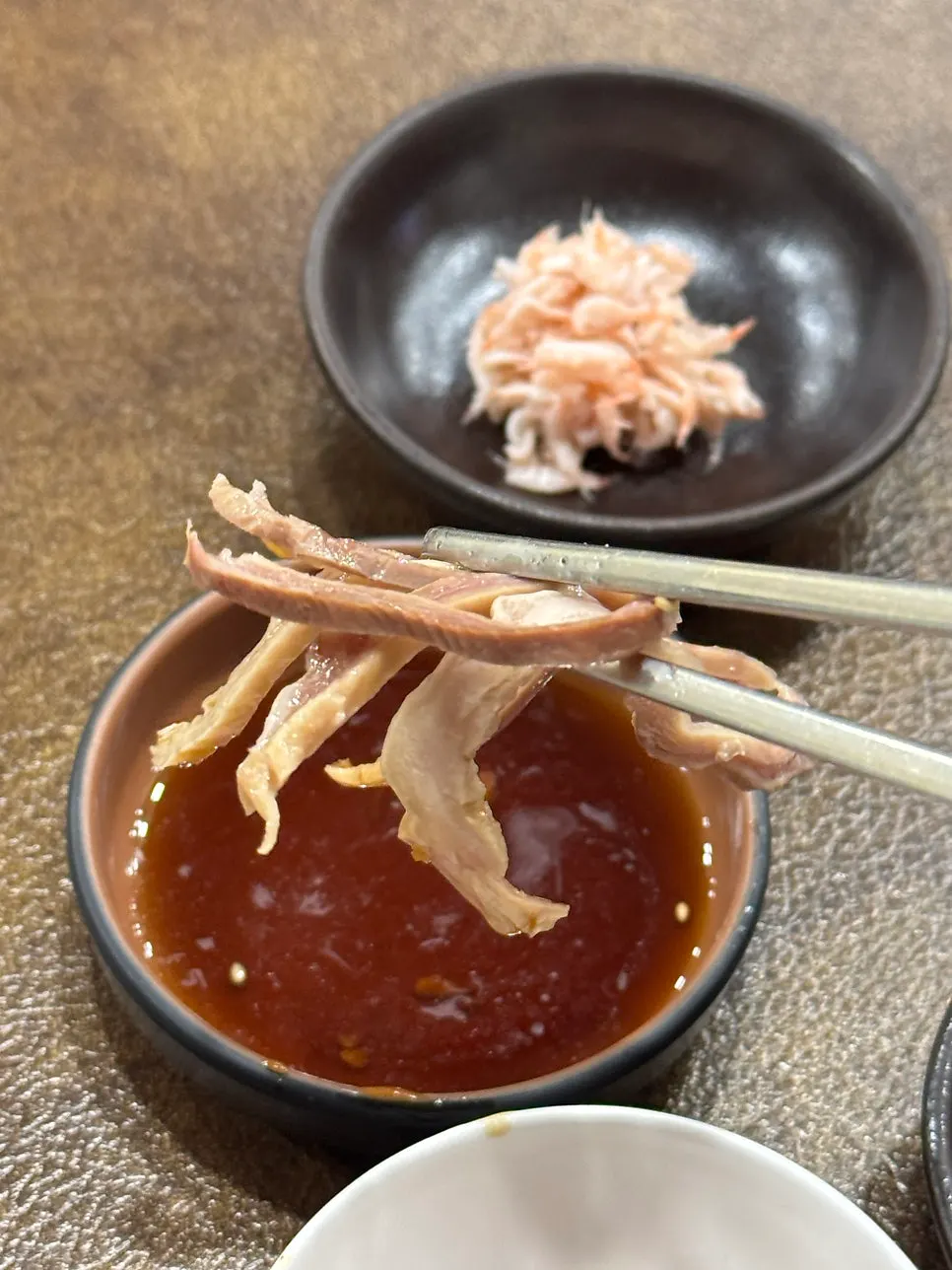A piece of suyuk picked up with chopsticks